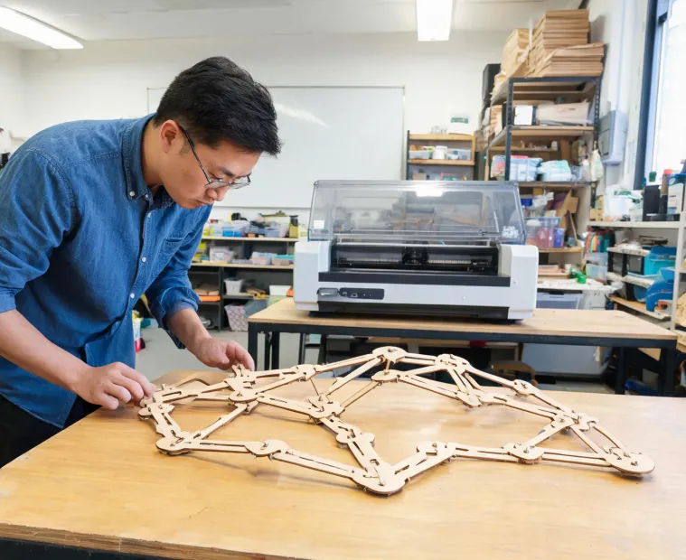 Teacher inspecting a laser-cut classroom mechanism